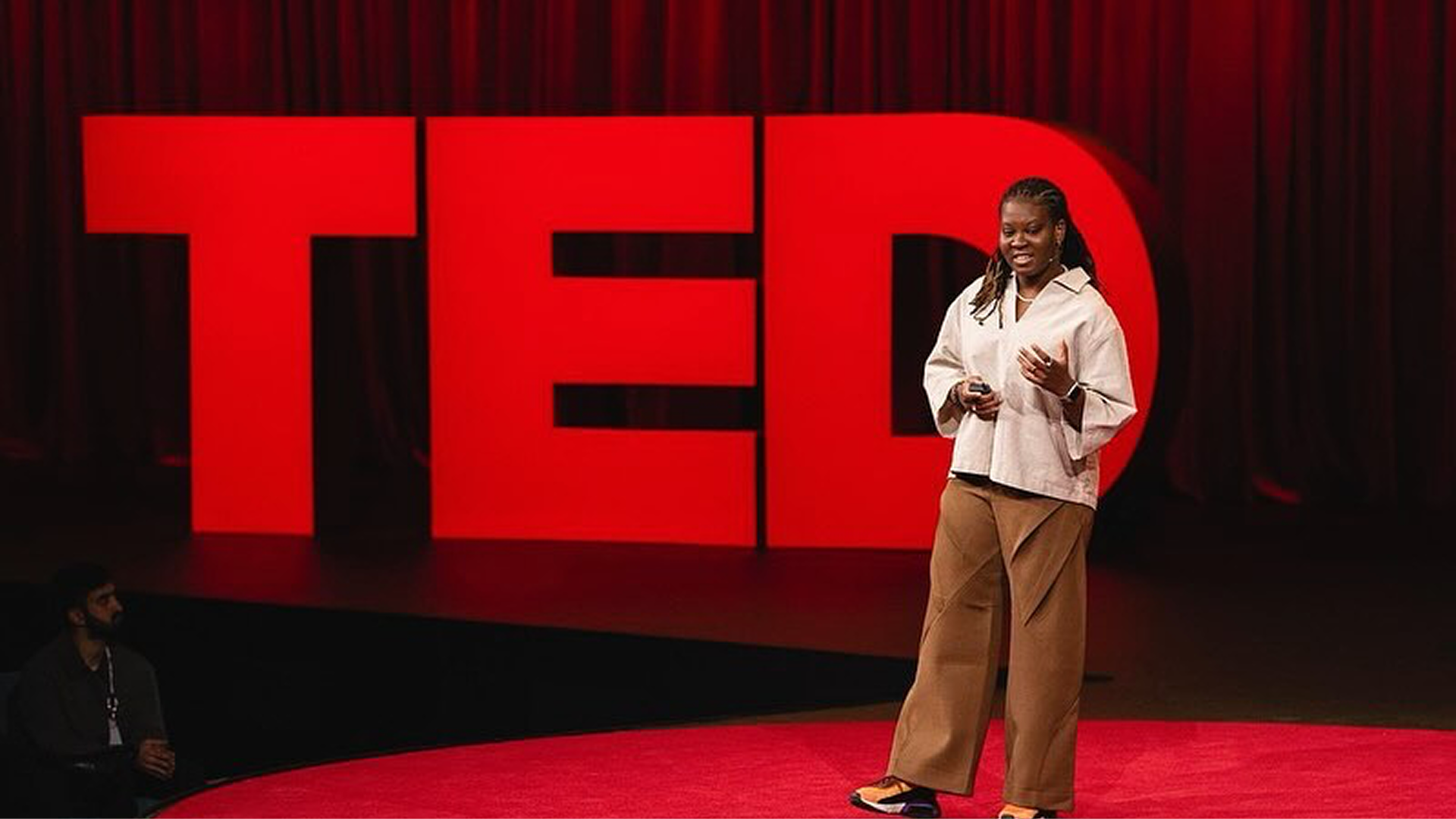 Photo of Peace Itimi speaking at a TED event